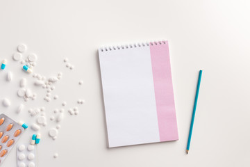 Medicaments, pencil and notebook on white background. Medical concept. Flat lay.