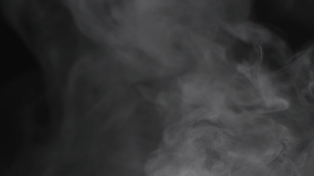 Slow motion of water vapor cloud comes from below over black background