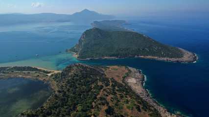 Obraz premium Aerial drone photo of iconic secluded sandy beach with emerald sea in island of Sfaktiria next to bay and famous beach of Divari (chrysi akti), Messinia, Gialova, Peloponnese, Greece