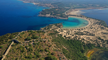 Aerial drone view of semicircular sandy beach and lagoon of Voidokilia, one of the most iconic beaches in Mediterranean sea, with crystal clear turquoise sea, Messinia, Greece