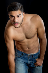 Fototapeta premium Young latin man poses for a portrait studio shirtless to show off his fitness. 
