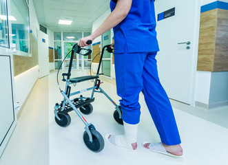 Patient on rollator with hand brakes moving in hospital