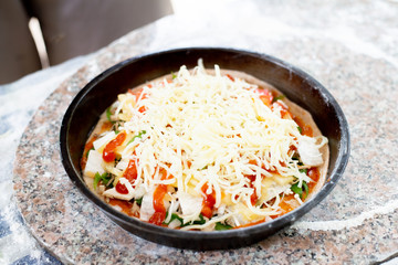 Put the cheese on the pizza in the tray.