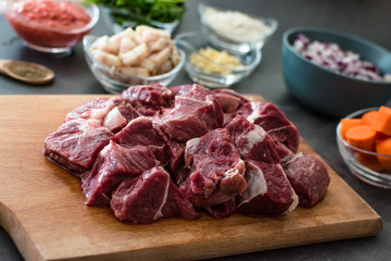 raw beef cubes on cutting board, meal prep concept