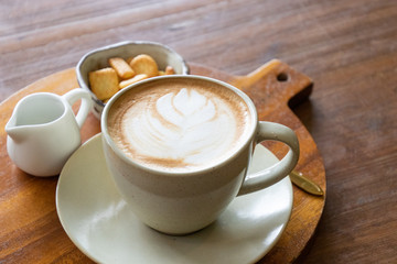 Coffee cup latte art with cookie and fresh milk breakfast set menu on wooden table