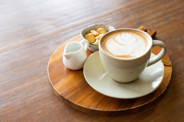 Coffee cup latte art with cookie and fresh milk breakfast set menu on wooden table
