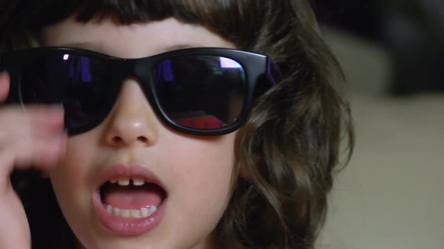 Very close up portrait of a female child performing a rock star with sun glasses FDV