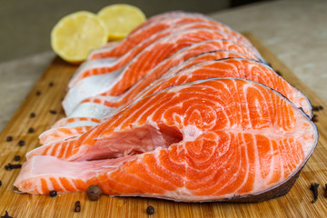 Red fish steak, freshly cut with peel on a cutting board