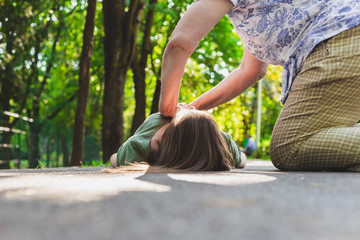 Unconscious fainted girl having cpr done by an old woman – Teenager lying on the ground while...