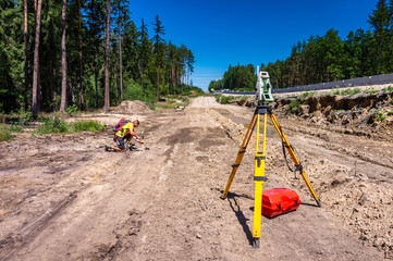 Surveyor engineer (worker) with equipment (theodolite or total positioning station) on the...