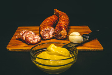 Traditional sausages made of delicious pork meat – Rustic raw food in front of some garlic seeds...