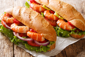 Healthy sandwiches with king prawns, summer vegetables close-up on paper. horizontal