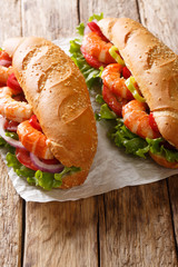 Fresh Sandwich with king prawns, vegetables close-up on parchment. Vertical