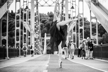 Young ballerina dancing in city streets, feeling breath of big city life and freedom 