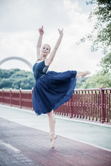 Young ballerina dancing in city streets, feeling breath of big city life and freedom 