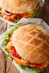 Greek pita with shrimps, vegetables close-up on parchment. Vertical top view