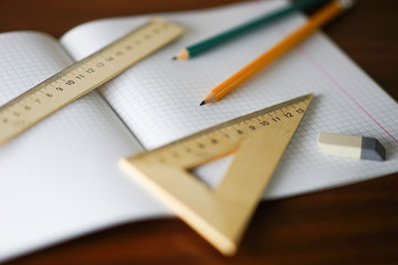 stationery, office supplies on the table, open notebook, rulers, pencils and an eraser