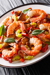 Stir Fried Shrimp with mushrooms and vegetables close-up on a plate. vertical