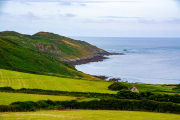 Fototapeta na wymiar Beautiful landscape of north Devon coast with abandoned barn in bottom right corner