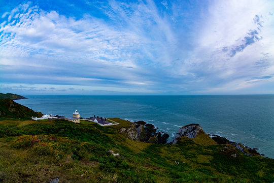 Super wide angle picture of a lighthouse in north Devon with beautiful sky and rocky coastline