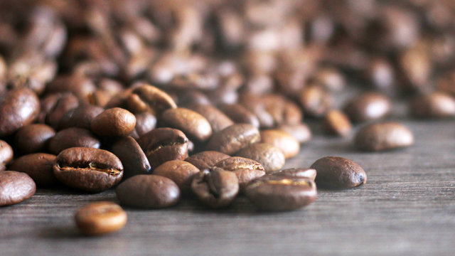 fresh coffee beans on wooden background, white steam