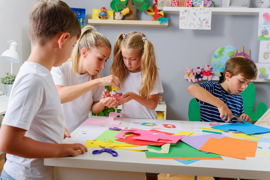 Mother or school teacher with children. Creative arts and crafts project at school or at home.