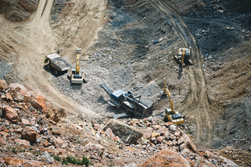 Excavator loading dumper truck on mining site stock photo