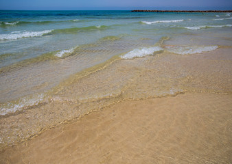 Soft blue ocean wave on sandy beach. Bottom. White sand on the beach with turquoise water in Djerba, Tunisia.