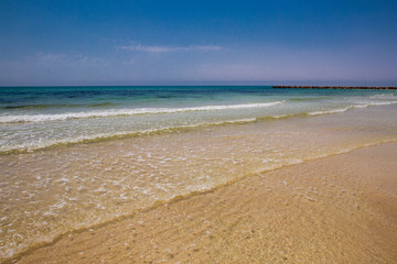 Fototapeta premium Soft blue ocean wave on sandy beach. Bottom. White sand on the beach with turquoise water in Djerba, Tunisia.