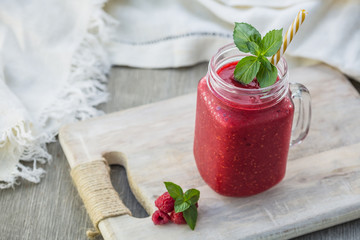 Photo of raspberry smoothie in jar with straw on light background. Fresh organic Smoothie. Health...