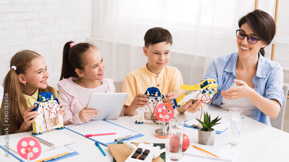 Poster kids creating robots with teacher in classroom