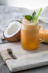 Photo of melon smoothie in jar with straw on light background. Fresh organic Smoothie. Health or detox diet food concept.