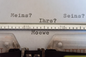 Typewriter  with a leaf and the words Meins?, Seins?, Ihrs? und Moewe (Mine ?, His ?, Yours? and...