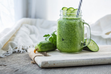 Photo of green cucumber smoothie in jar with straw on light background. Fresh organic Smoothie. Health or detox diet food concept. - 280785489