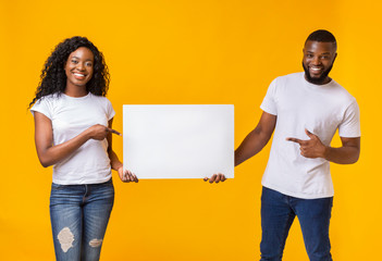 Afro couple is holding white advertising board