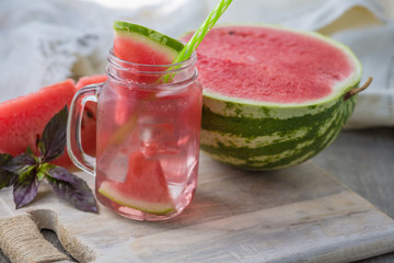 Home fizzy drink with ice and watermelon on a light background, selective focus. Photo of home made refreshing beverage