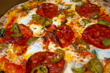 brick oven Neapolitan-style pizza with spicy Hot Soppressata, fresh mozzarella, fresh basil in a pizza box