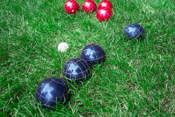 Recreational italian sport whit, red, dark blue bocce balls on a green lawn