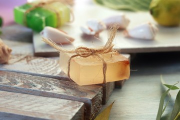 Natural soap, lighted candles, flower, sea stones and shells on a wooden table, spa procedures, body care, healthy lifestyle
