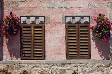 Fototapeta na wymiar two closed window shutters on the red wall of the house in Turkey