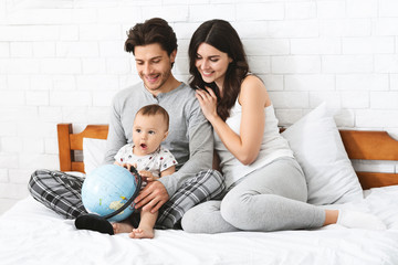 Fototapeta premium Happy family preparing to travel trip, learn for route on globe