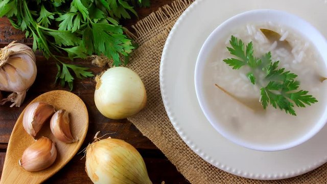 congee in ceramic bowl on rustic wooden table, traditional rice porridge typical of Asian cuisine