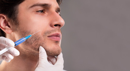 Young man getting anti aging injection in jaw