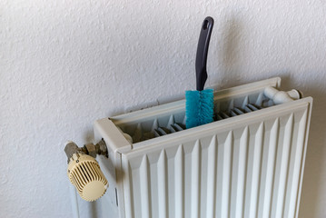 cleaning of the heater or radiator on the wall - blue brush 