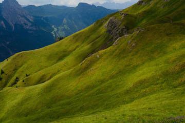Pendio erboso in alta montagna con contrasti di luci e ombre
