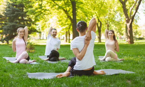 Group of people practicing yoga, sitting in Cow Face exercise