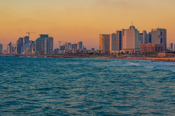 Fototapeta premium beautiful Tel Aviv Israeli capital city with skyscrapers buildings on Mediterranean sea wavy waterfront landmark and landscape photography in colorful sunset evening time