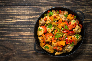 Obraz na płótnie Canvas Chicken Stir fry with vegetables on wooden table.