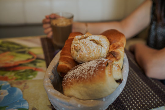 Food photography. Hot cappuccino with different homemade pastries in a basket on the table in fast food cafe.