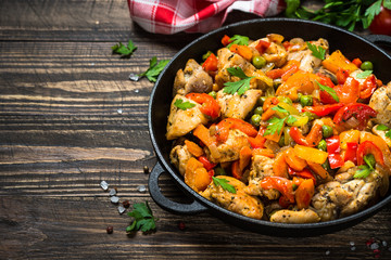 Chicken Stir fry with vegetables on wooden table.